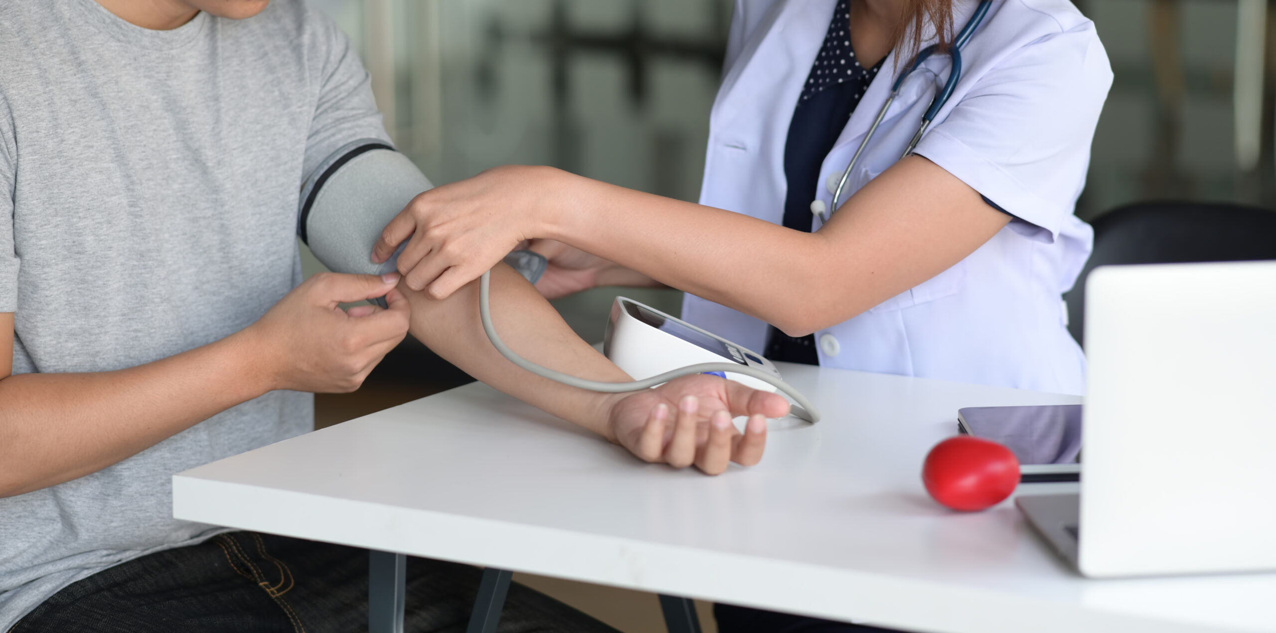 Woman doctor and patient measuring blood pressure in office